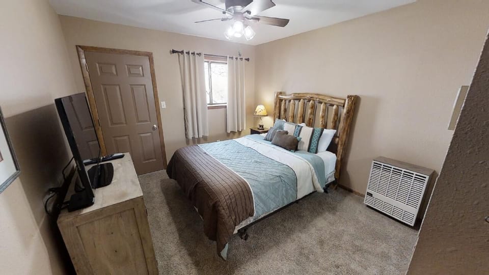 Unwind in your cozy bedroom with rustic log-style charm, soft linens, and a ceiling fan to keep you comfortable throughout your stay.