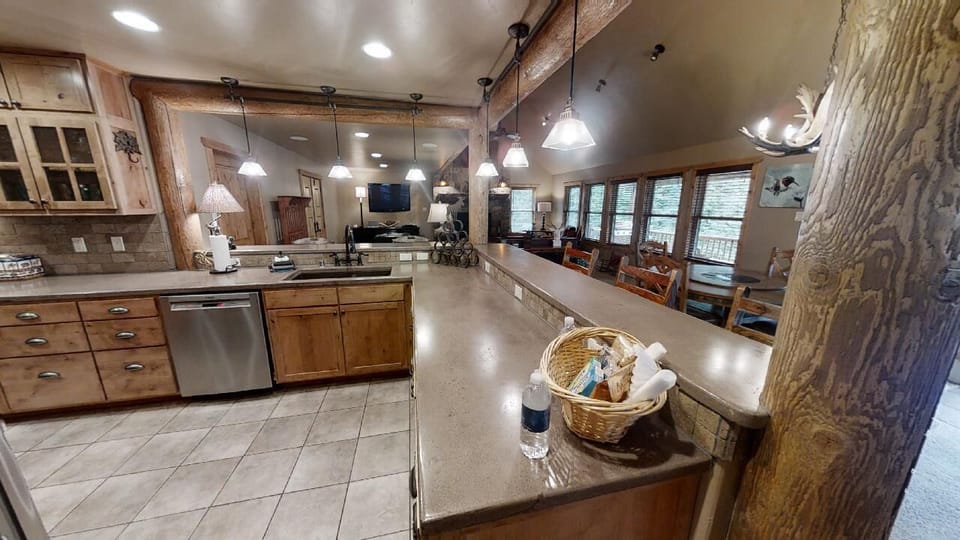 Step into your mountain-style kitchen featuring granite counters, stainless appliances, and an oversized island perfect for gathering. Pendant lighting and rustic wood details create a welcoming space where you can cook, dine, and relax together.