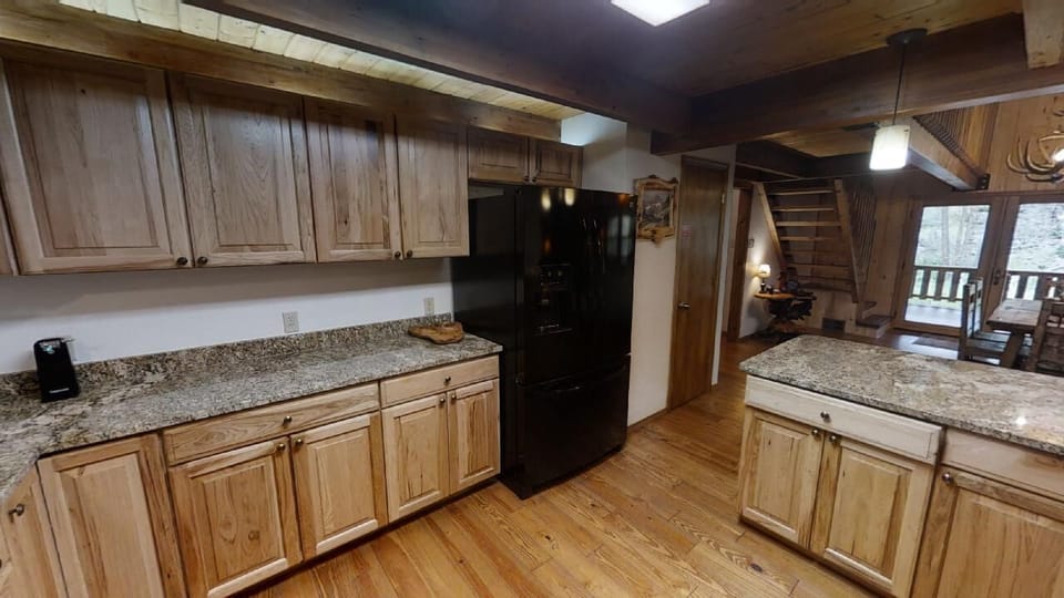 Your spacious kitchen features granite countertops, full-sized appliances, and rustic wood cabinetry, giving you plenty of room to prepare meals and gather with loved ones during your mountain getaway.