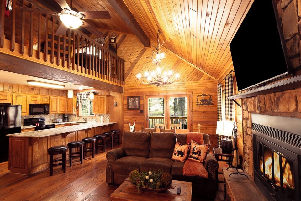 Gather in your open-concept retreat where soaring wood ceilings, a cozy stone fireplace, and a fully-equipped kitchen create the perfect backdrop for memorable mountain evenings together.