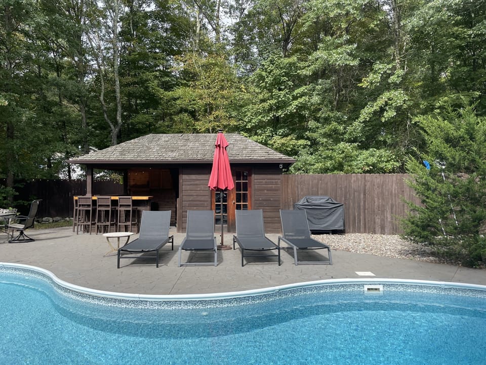Patio loungers, pool bar and pool house.