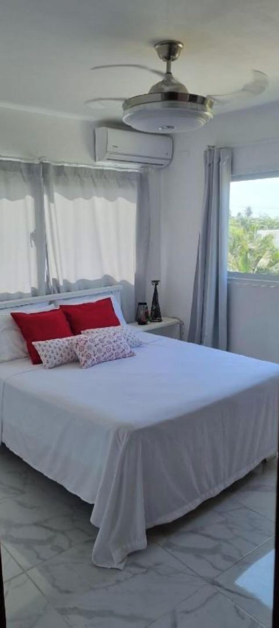 Room with double bed, air condition and ceiling fan.