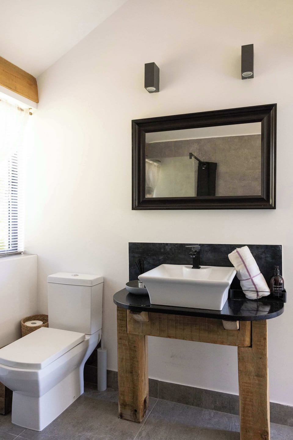Refresh in this modern bathroom featuring sleek fixtures and stylish rustic wooden details.