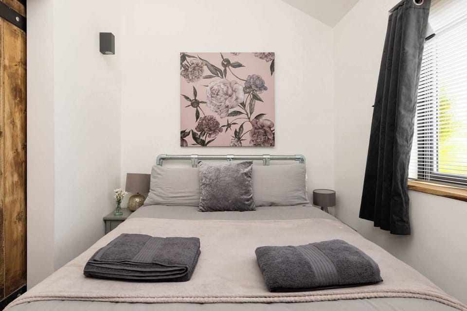 Relax in this tastefully furnished double bedroom featuring cozy bedding and charming rustic details.