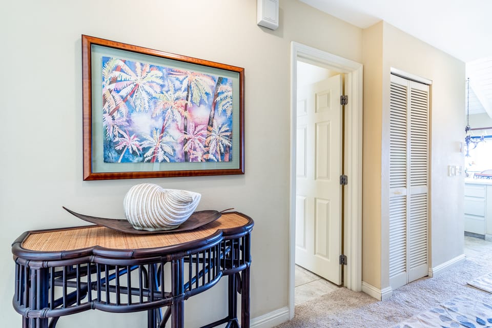 Step into a thoughtfully designed hallway with tropical artwork and stylish furnishings that welcome you to your island retreat, with quick access to all your spaces.