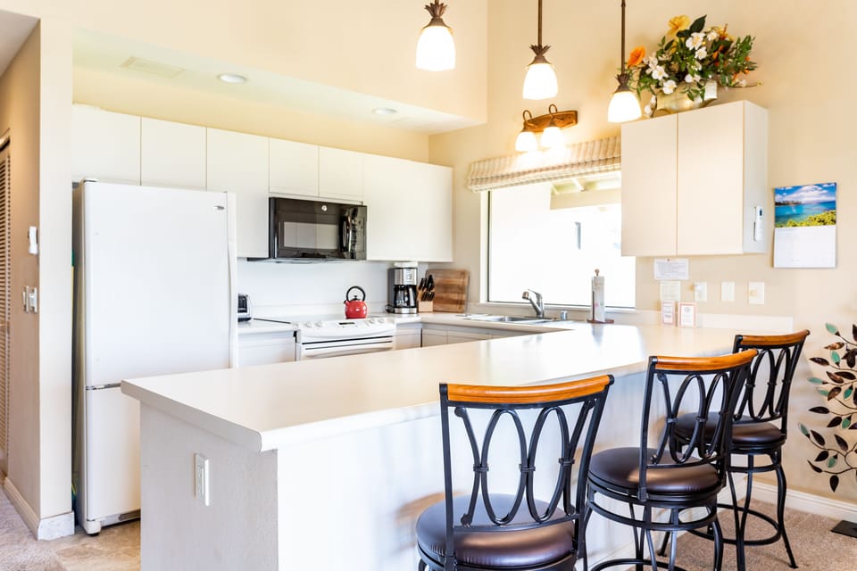 Your fully equipped kitchen invites home-cooked meals with modern appliances, bright countertops, and a cozy breakfast bar perfect for morning coffee or casual dining.
