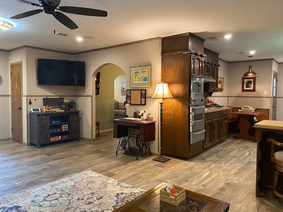 Main living space with 55 inch flatscreen TV, flows into dining room