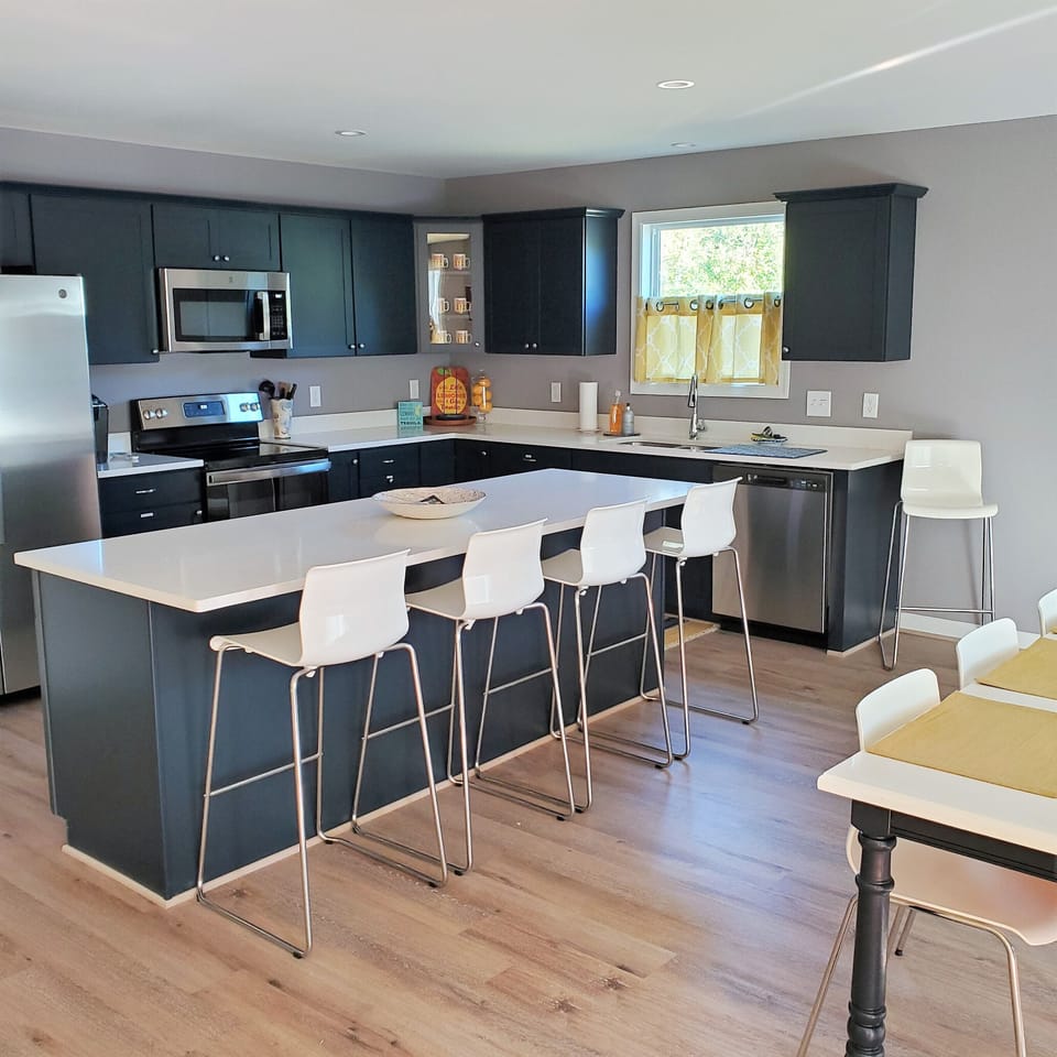 The kitchen & DR area is open & spacious. Custom cabinetry in navy blue.