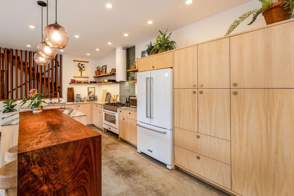 Fridge, oven, sink, drawers, oepn space, table, chairs