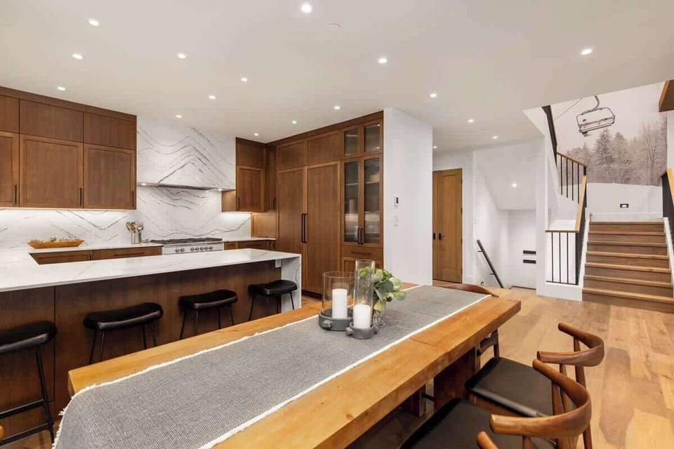 - Elegant dining setup beside gourmet kitchen with marble finishes  
- Warm lighting and natural wood tones enhance alpine comfort  
- Ideal for shared meals after a day on the slopes  