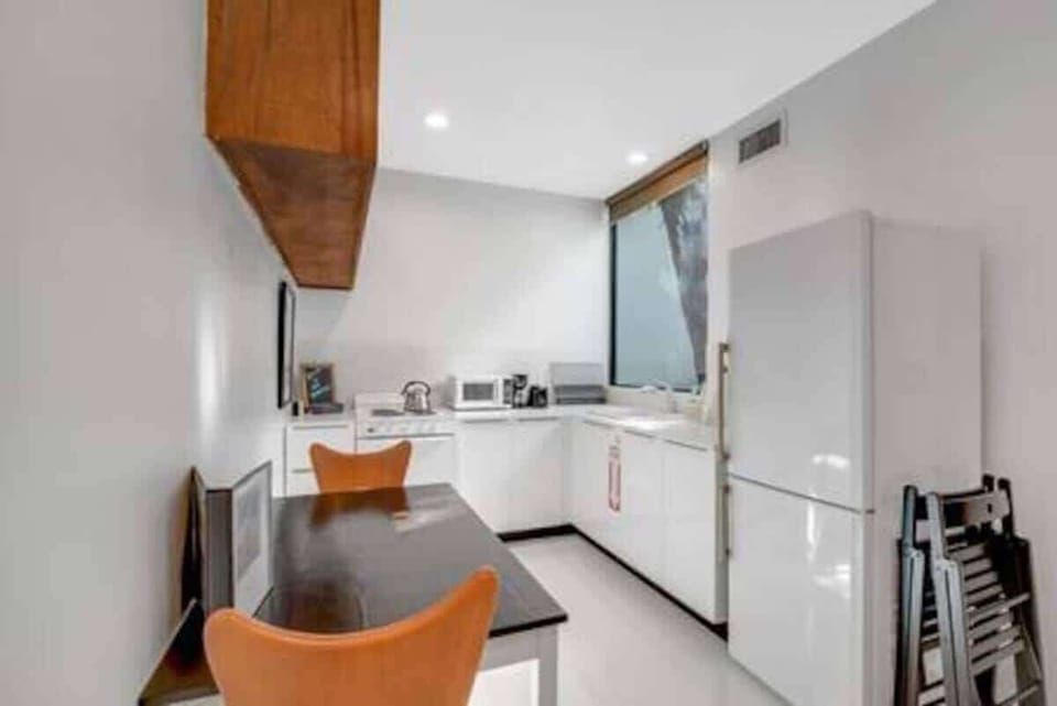 The kitchen is stocked with a full set of appliances including a basic kitchen utensils. 