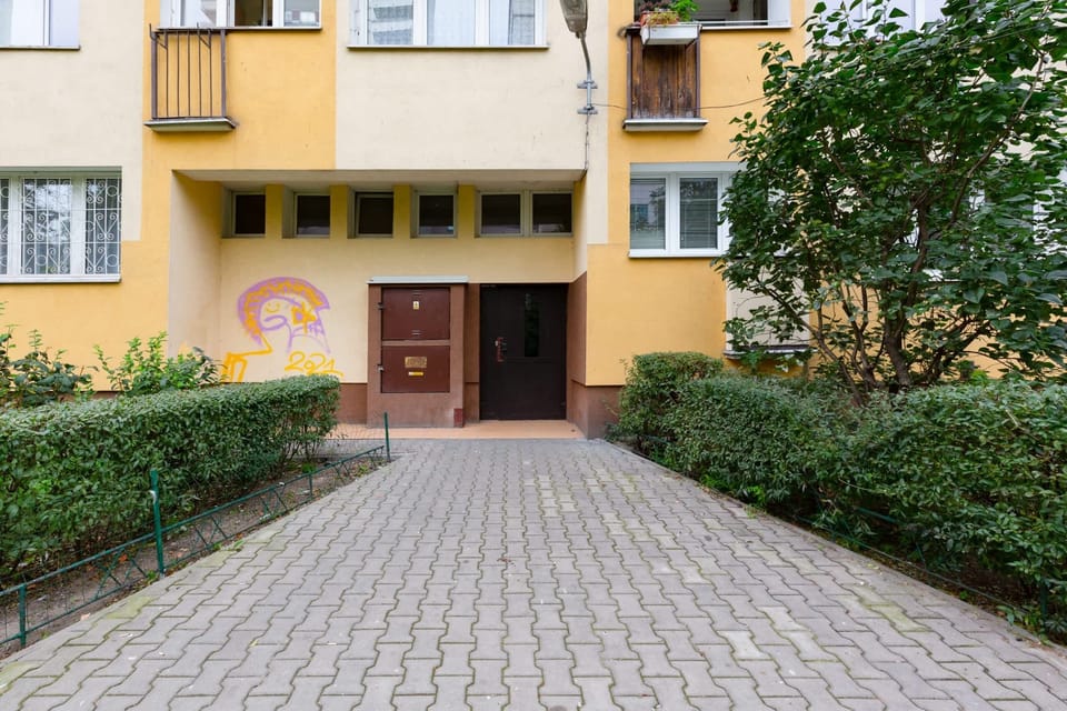 The exterior of the building, surrounded by lush greenery and well-maintained pathways.
