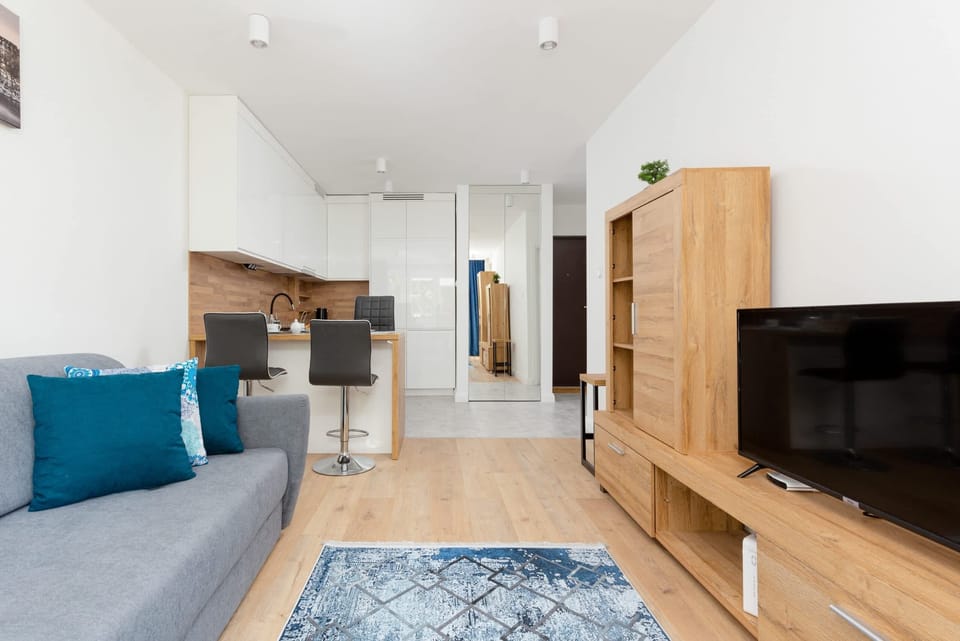 A stylish open-plan space connecting the living room and kitchen with elegant wooden details.
