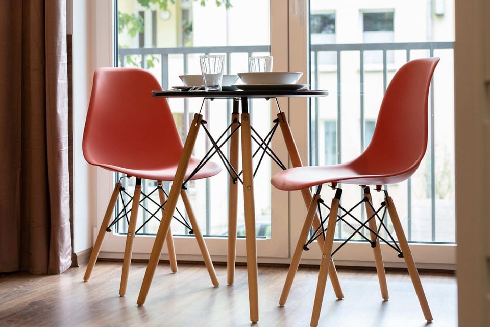 A dining area with a round table and red chairs, creating a vibrant and welcoming atmosphere.
