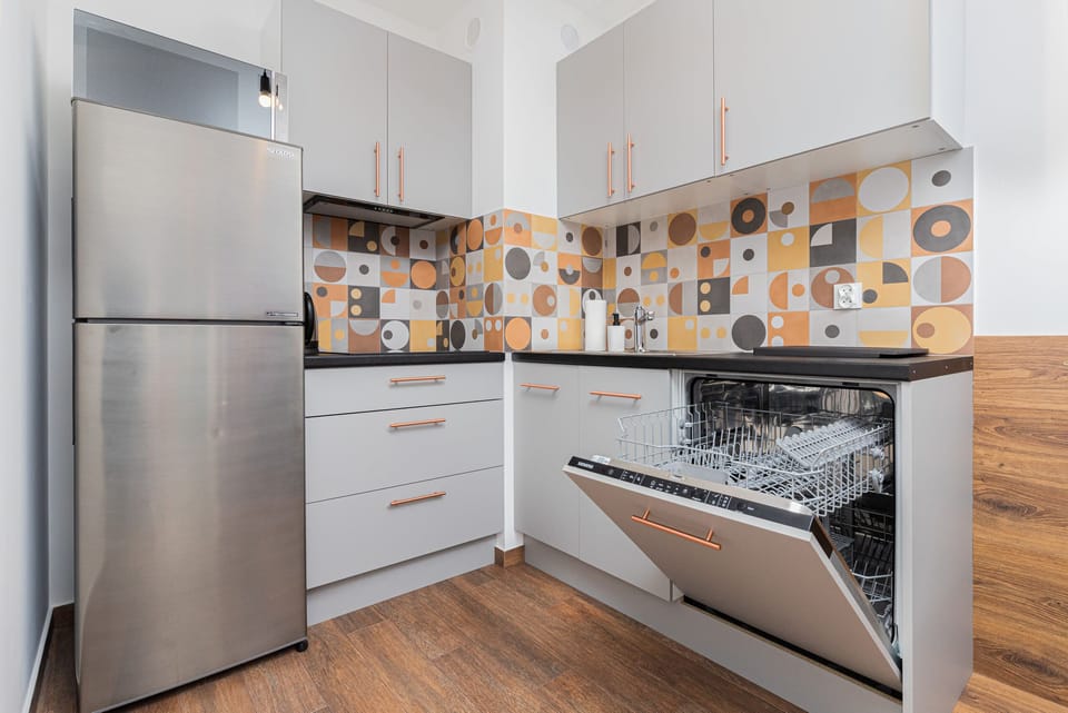 A fully equipped kitchen featuring modern appliances and a charming design.
