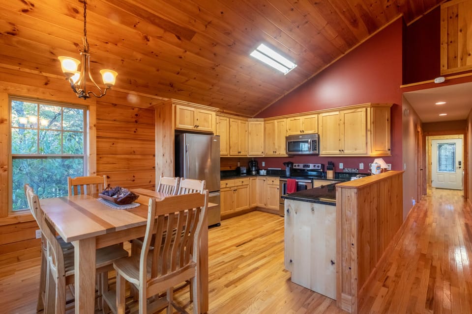 Warm knotty pine surrounds a full kitchen and dining table for the whole crew at Firefly Cabin in Banner Elk.