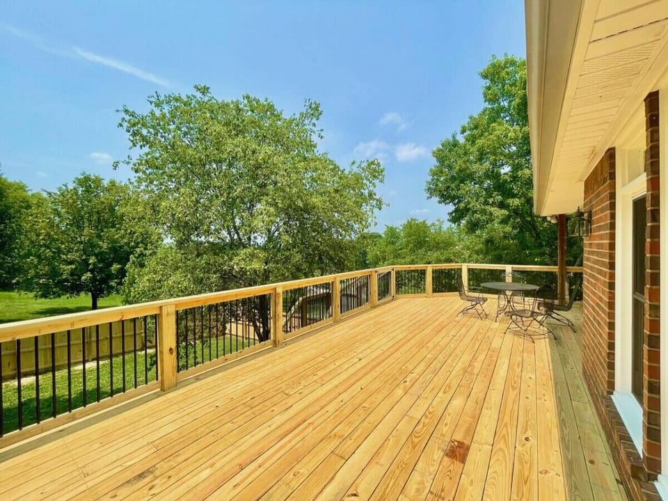 Impressive deck with grill and outdoor seating, table, and sun loungers