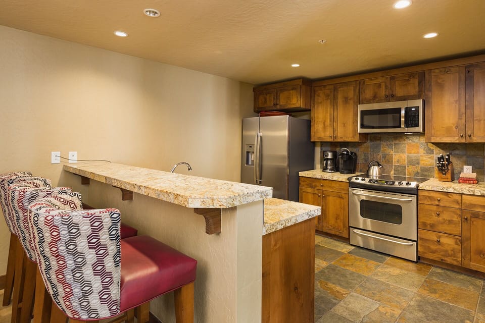 Kitchen and bar area. Fully stocked with cookware and dishware.