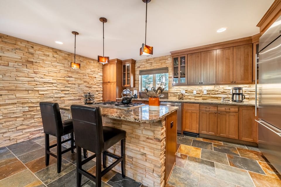 Cook gourmet meals in your stunning granite kitchen with warm wood cabinetry and stone accents.