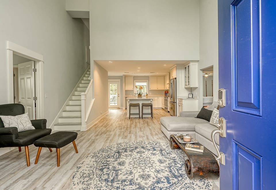 Main entrance to home with view of living room, kitchen, 2-bedrooms on left, master bedroom on right and stairs to the upstairs bedroom.