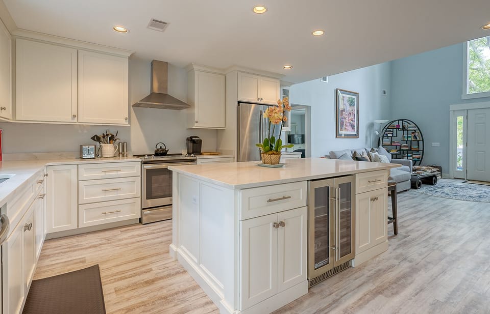 Spacious kitchen with stainless steel appliances, overlooking the living room.