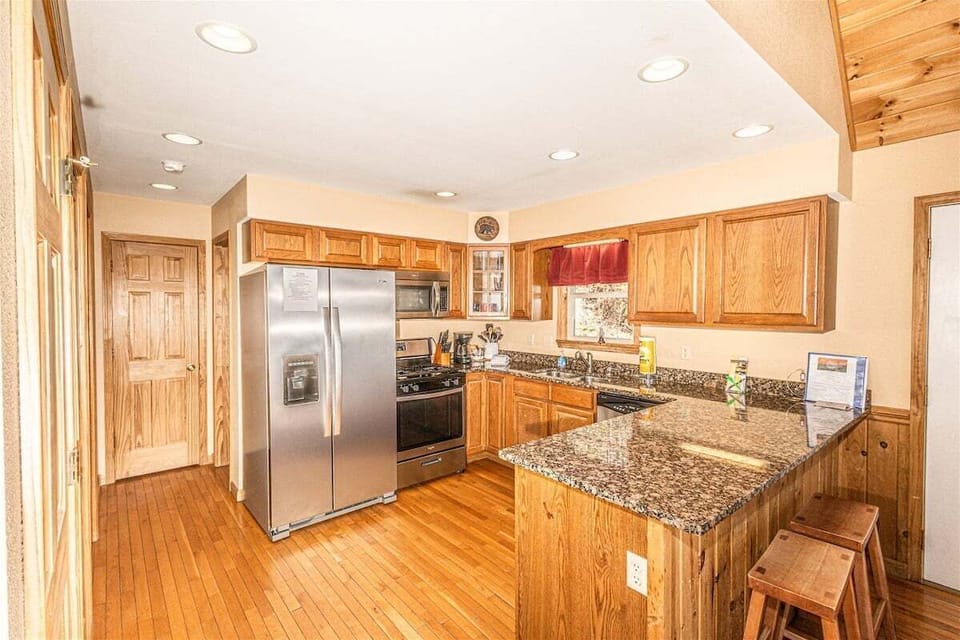 Full kitchen featuring granite countertops, stainless steel appliances, and bar seating. Open layout connects seamlessly to the main living space.