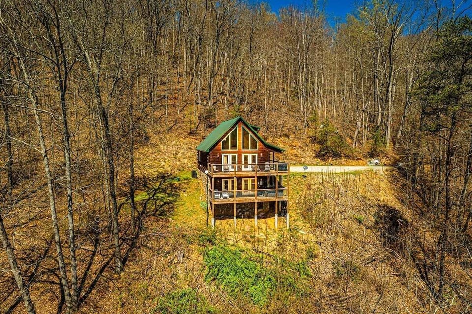 Elevated cabin nestled among mature trees on a mountainside in the Bryson City area. Multi-level decks overlook the surrounding forest.