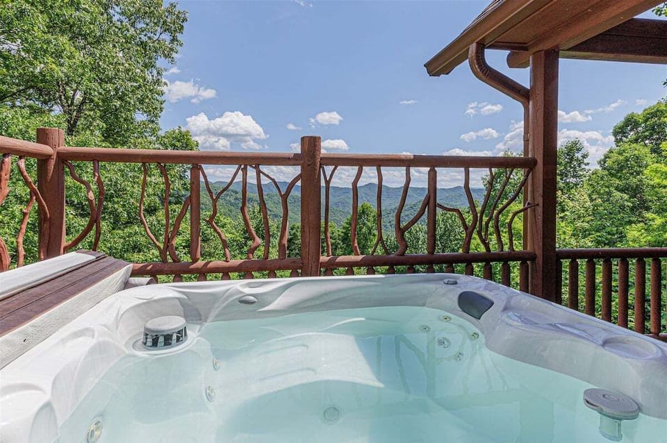 Outdoor hot tub on the deck overlooking the trees and distant hills perfect for soaking under the stars or cooling off after a hike.