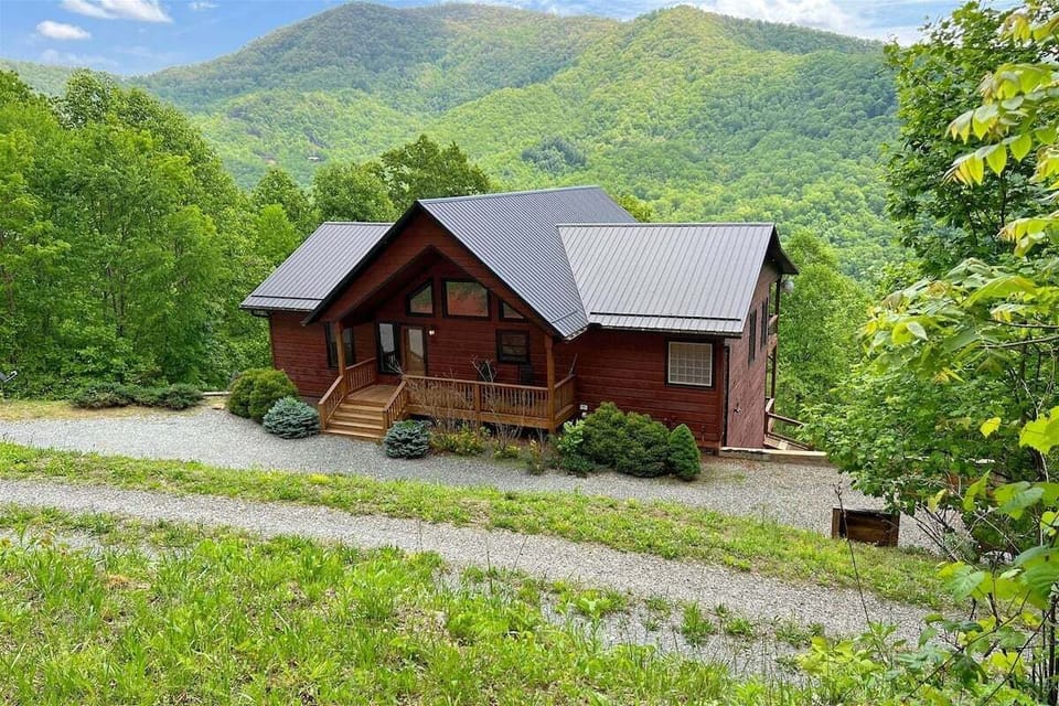 Smoky Mountain High in Bryson City sits perched on the hillside with dramatic long-range Smoky Mountain views, blending rustic charm with modern comfort.