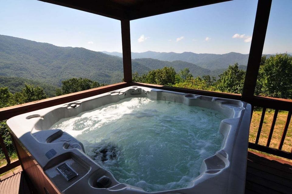Private hot tub on the covered deck at A Walk in the Clouds overlooking Bryson City mountain views. Located near Nantahala Outdoor Center and Great Smoky Mountains attractions.