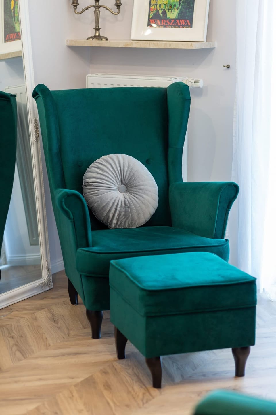 A luxurious green armchair with a soft pillow and a side table, perfect for reading or relaxing.