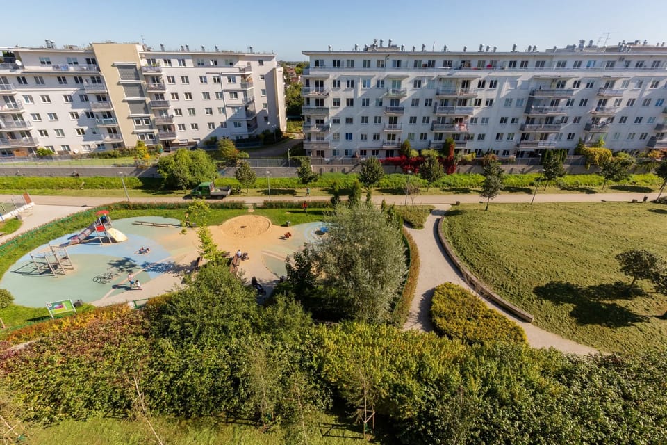 A view of the lush, green outdoor surroundings with walking paths and recreational areas near the apartment complex.