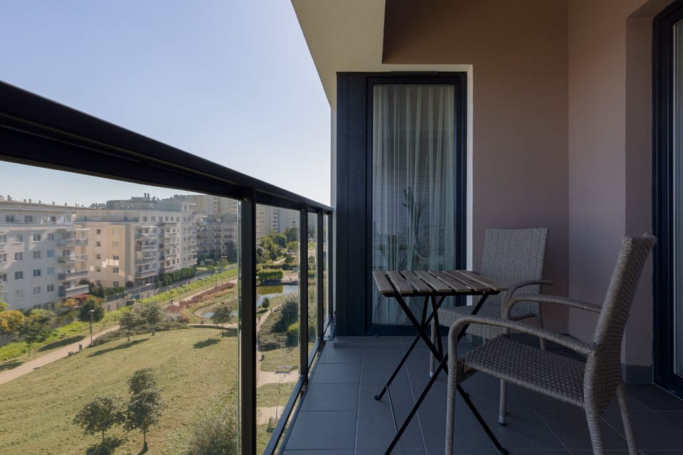 A charming balcony with outdoor seating, offering views of the surrounding greenery and a perfect spot to unwind.
