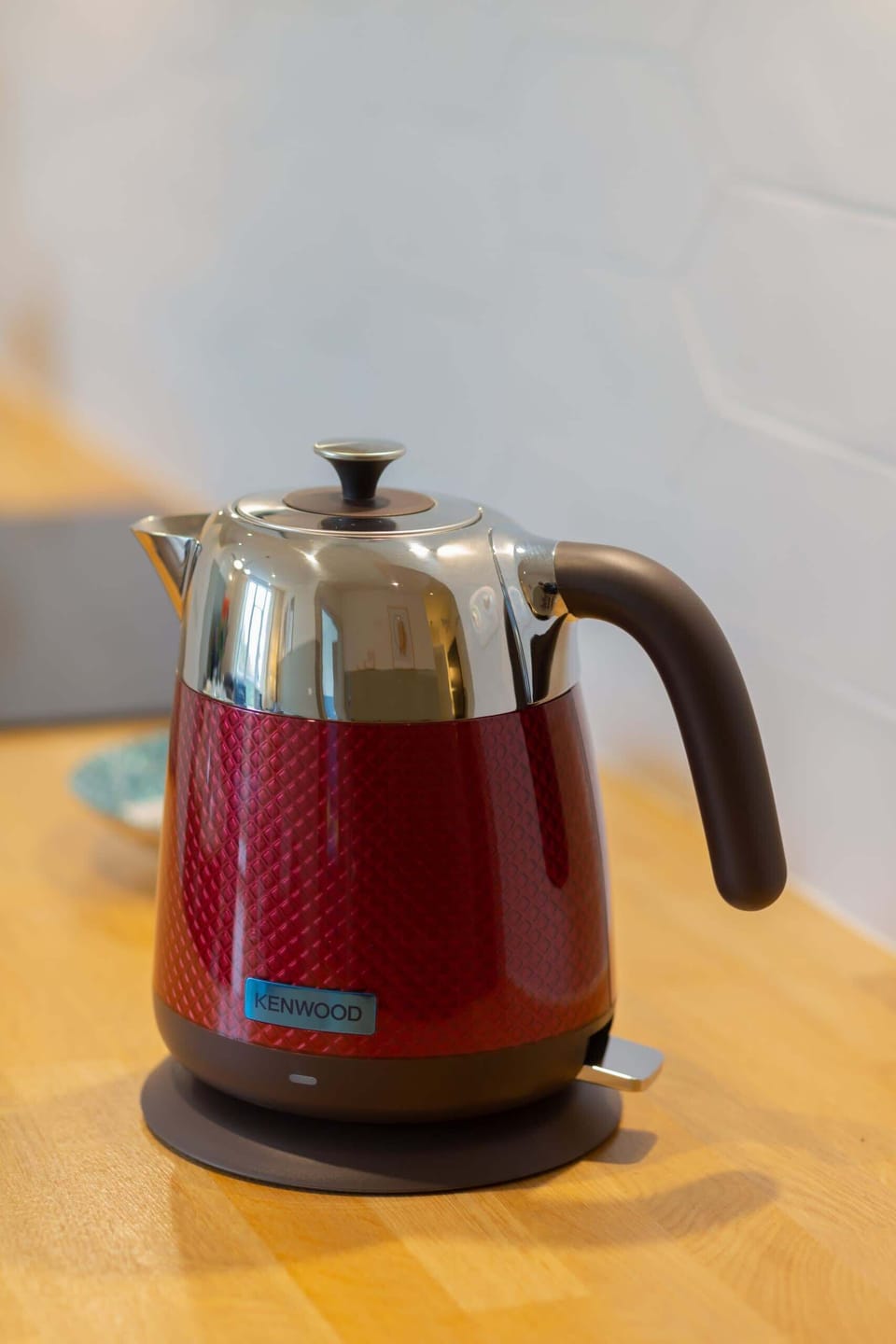 A close-up of a red electric kettle on the kitchen countertop, ready for your convenience.
