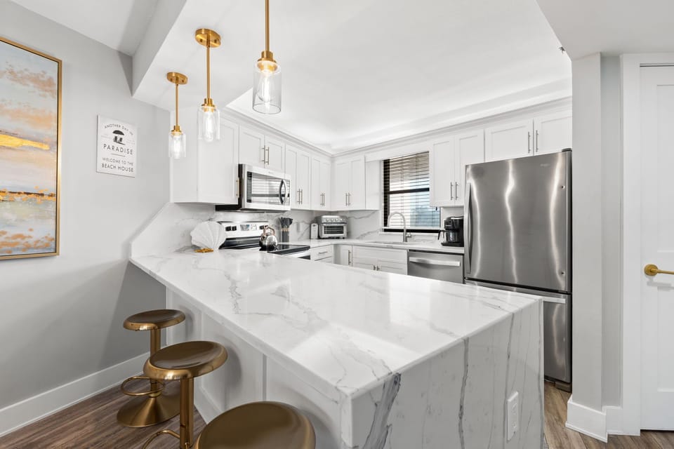 Fully equipped kitchen near dining area with breakfast bar seating three guests.

Professionally Managed by
Breathe Easy Rentals
