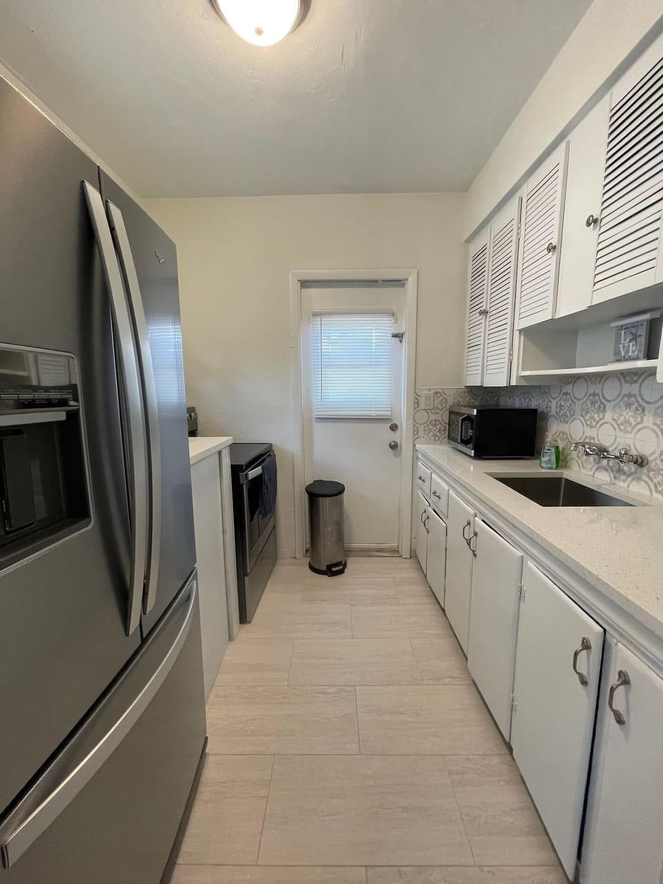 Updated kitchen featuring quartz countertops and stainless steel appliances