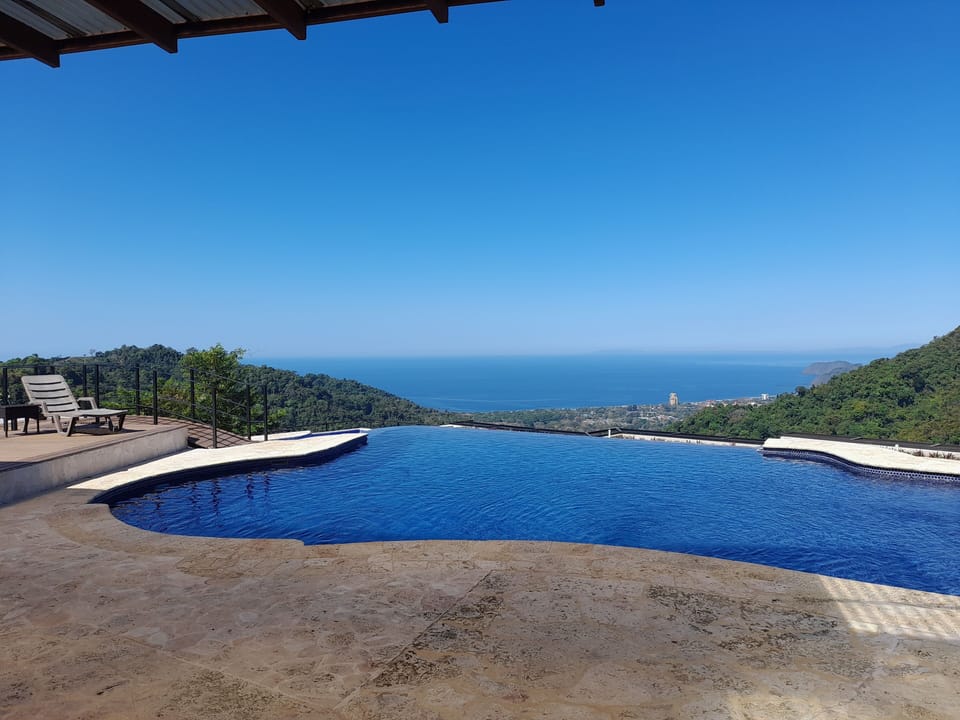 Infinity edge swimming pool adjacent to sun deck, BBQ bar and covered terrace!