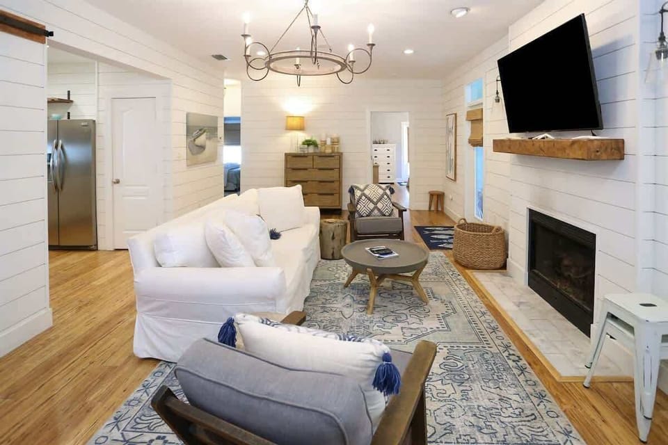- Kick back in this inviting living room featuring shiplap walls, a fireplace, and plush seating - Thoughtfully styled with farmhouse charm and modern touches throughout - Gather for games, movies, or just cozy nights in by the fire