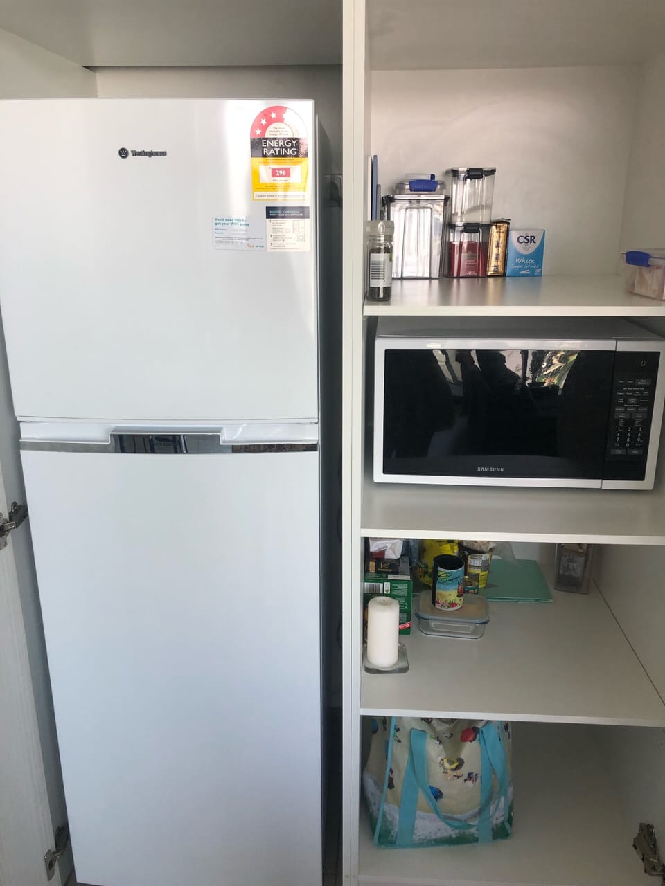 Fridge, microwave and pantry hidden neatly behind cupboards