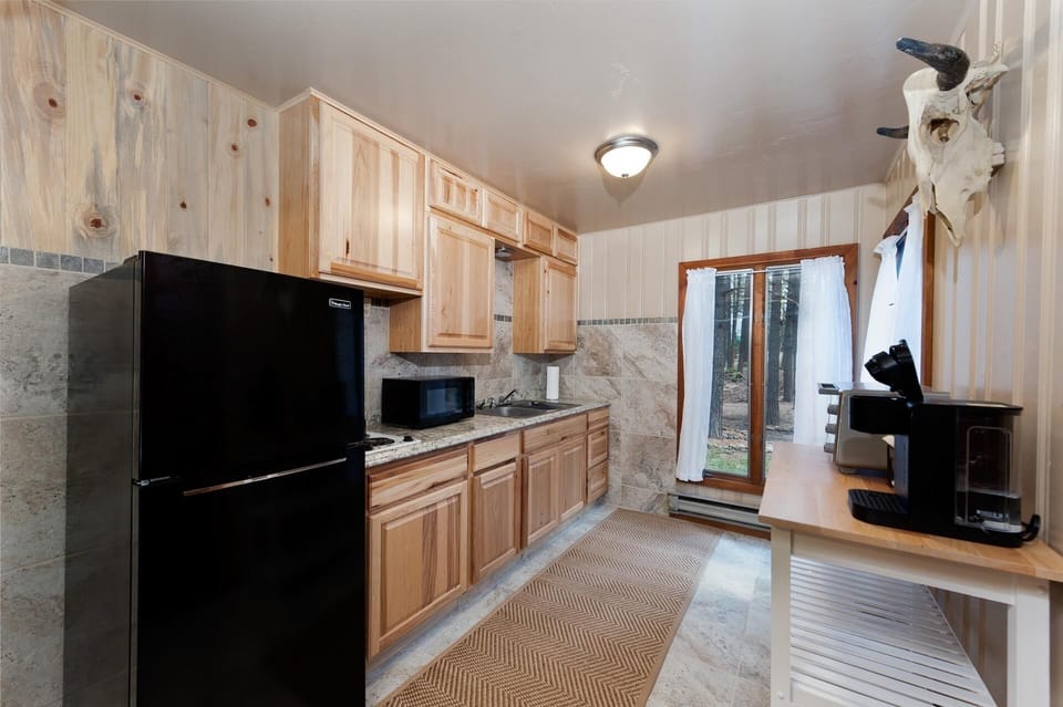 Kitchenette with toaster oven, microwave, coffee maker, and refrigerator.