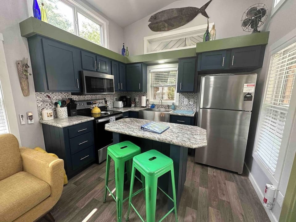 The dining area features a cozy counter with two bar stools—perfect for meals, morning coffee, or casual conversation.
