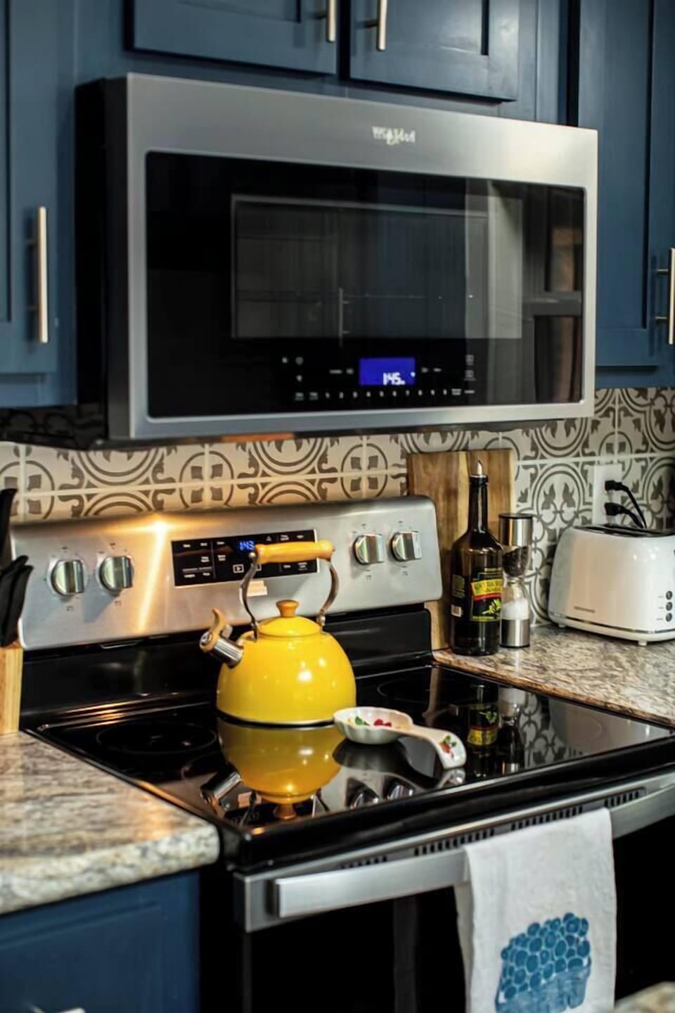 The kitchen includes a microwave, electric stove, and tea kettle, with salt, pepper, and olive oil provided for your convenience.