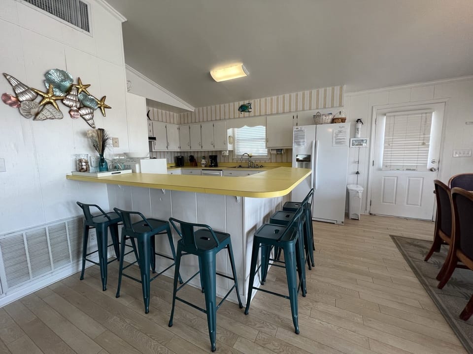 Your fully equipped kitchen features a spacious breakfast bar where you can gather for morning coffee or casual meals together.