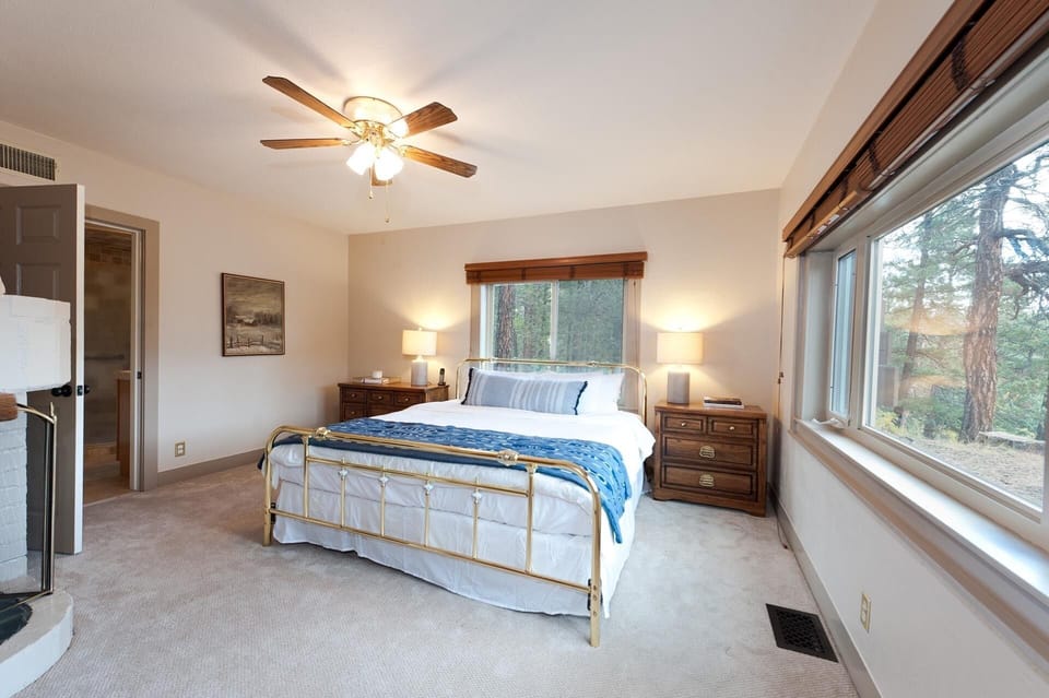 Master bedroom with king size bed, fireplace, ceiling fan, and TV