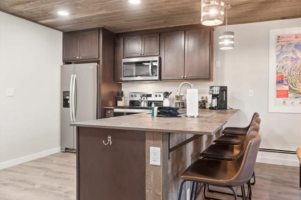 The fully equipped kitchen includes a spacious kitchen bar with four barstools.