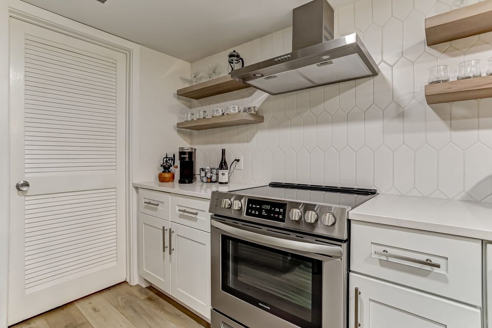 Fully Equipped Kitchen with Stainless Steel Appliances, Beautiful Quartz Countertops, and Open Shelving