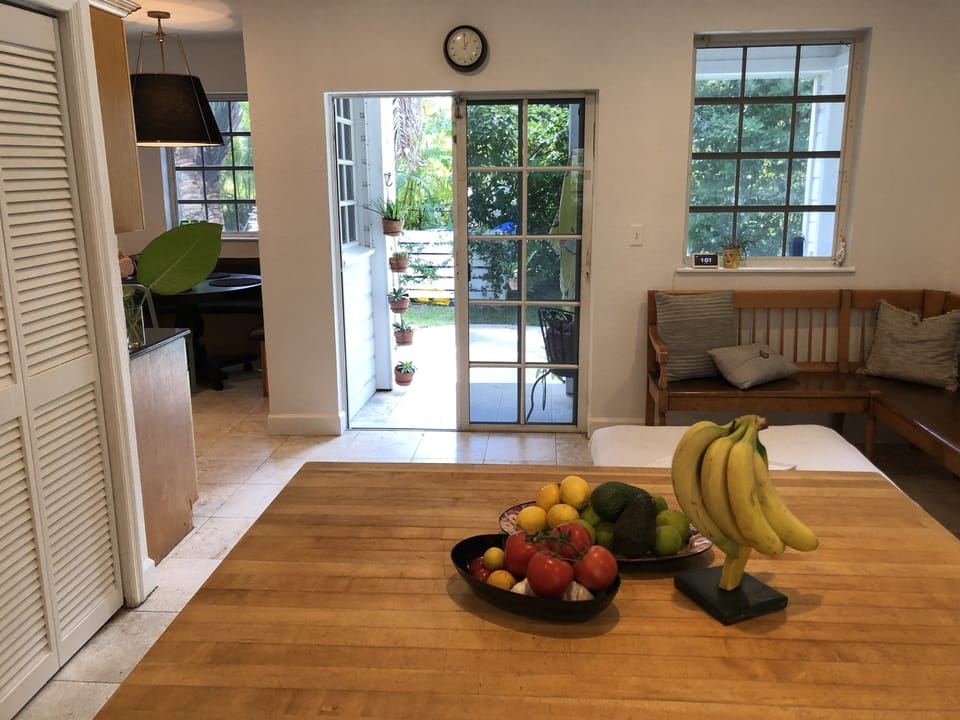 View from kitchen of sliding-door out to pool area and guest cottage