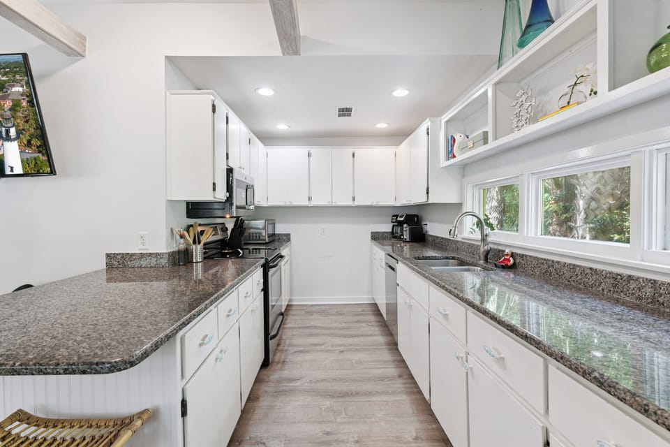 Your fully equipped galley kitchen features gleaming granite counters, crisp white cabinetry, and all the tools you need to whip up a delicious meal during your stay.