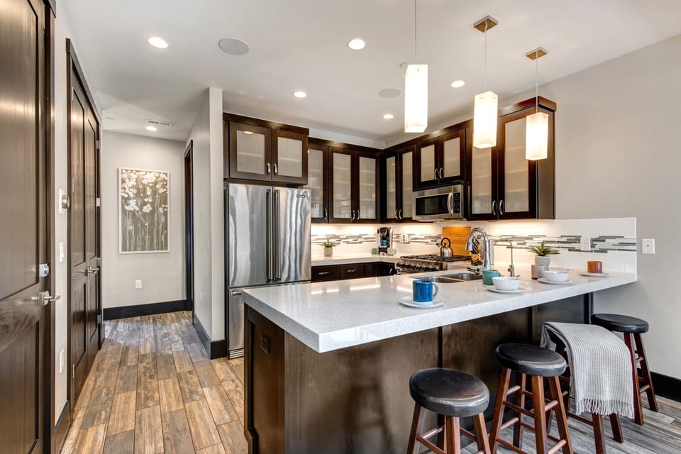 Fully Equipped Kitchen with beautiful stone countertops, stainless steel Viking appliances, and bar seating for four