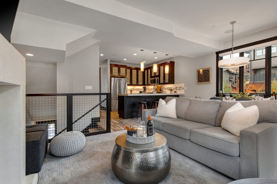 Living Room with plush contemporary furnishings including sofa bed, 55" TV, gas fireplace, and private balcony access
